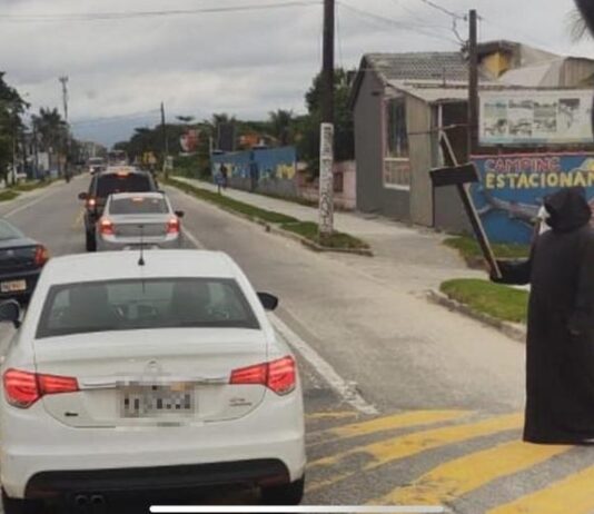 Homem vestido de morte recepciona turistas que insistiram em ir ao Litoral Norte